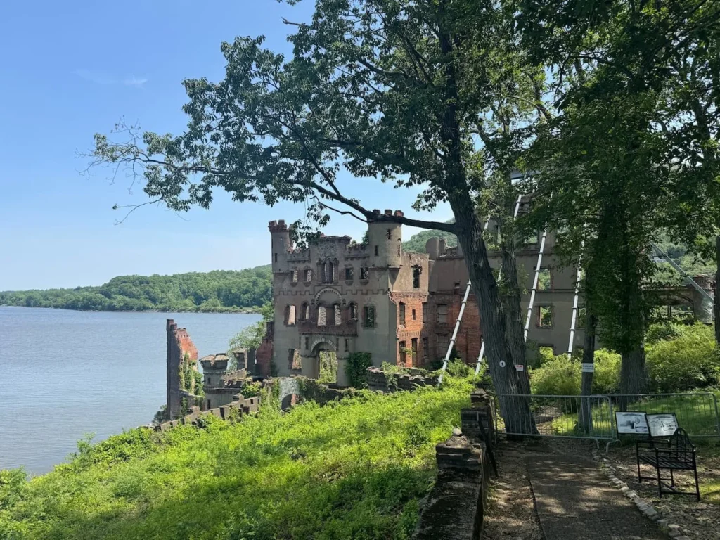 The ruins of a castle on an island surrounded by water on a sunny day.