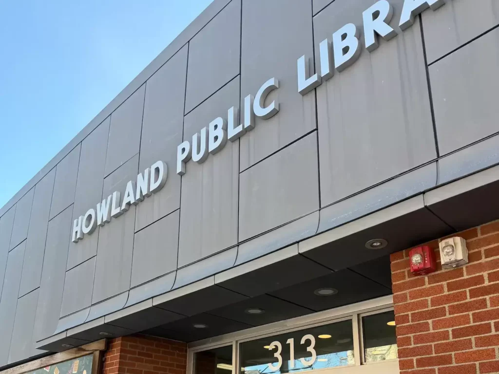 building with signage indicating Howland Public Library with street number 313.