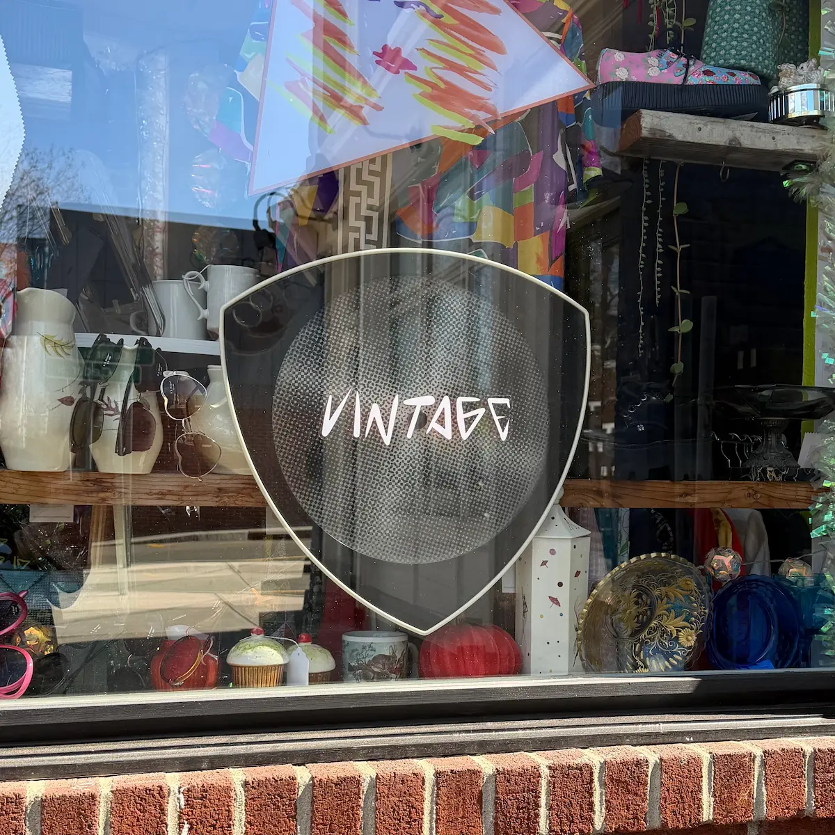 A window sign says vintage in a vintage clothing store.