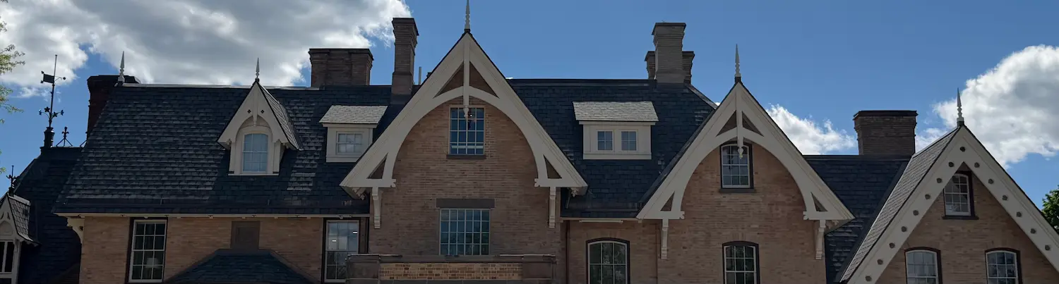 The top of a restored Victorian mansion or hotel with a blue sky in the background.