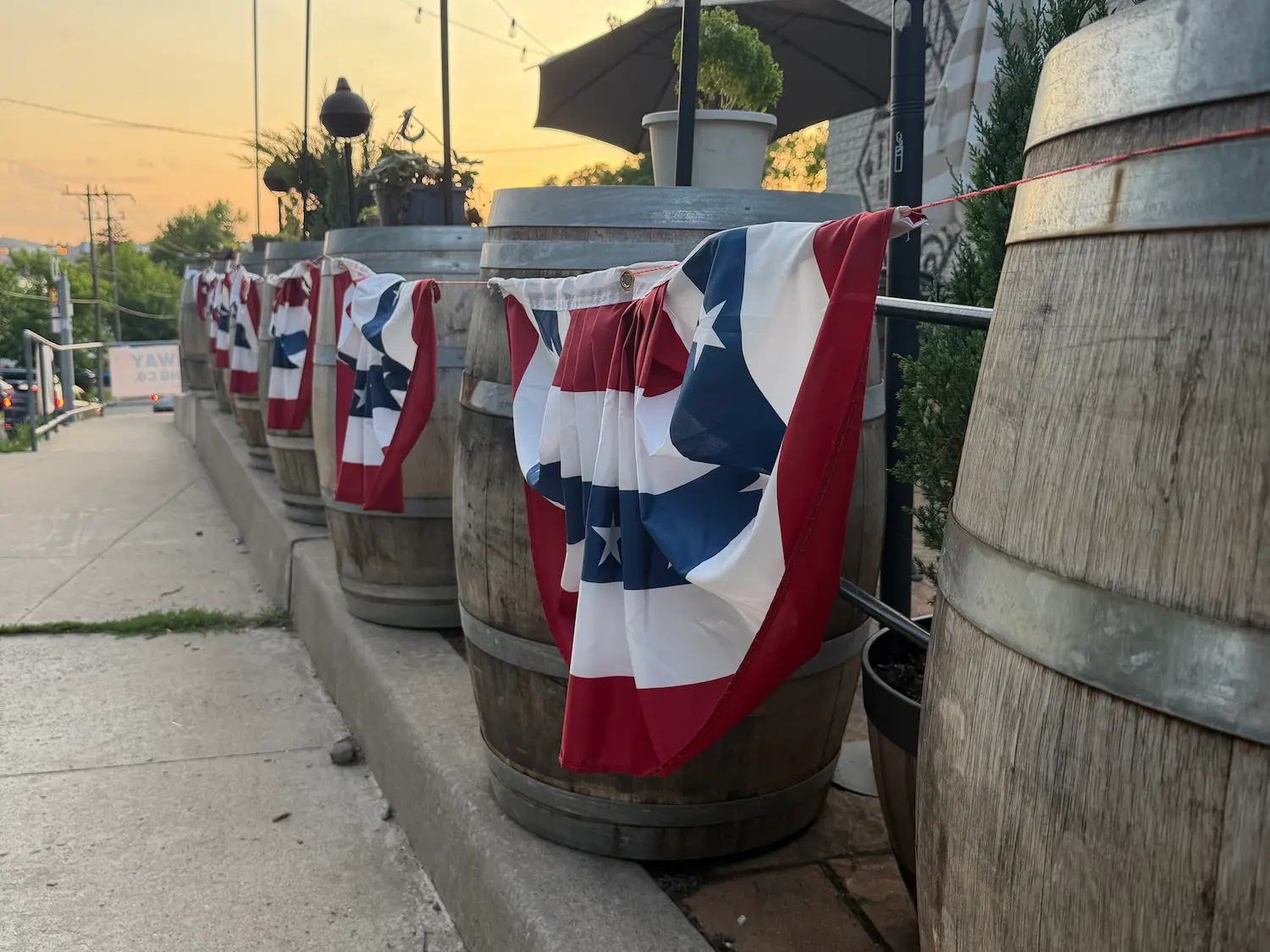 July 4th American flag bunting tied to barrels with a sunset in the background in Beacon, NY
