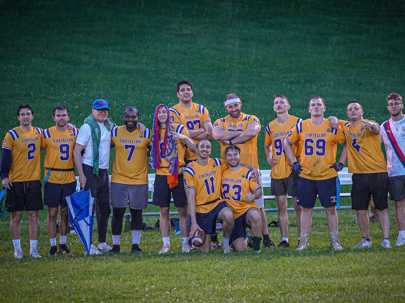 A team of flag football players from Beacon line up for a photo wearing yellow shirts and looking proud.